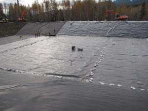 Installation of 2 layer liner system. Sandbags to secure from wind.